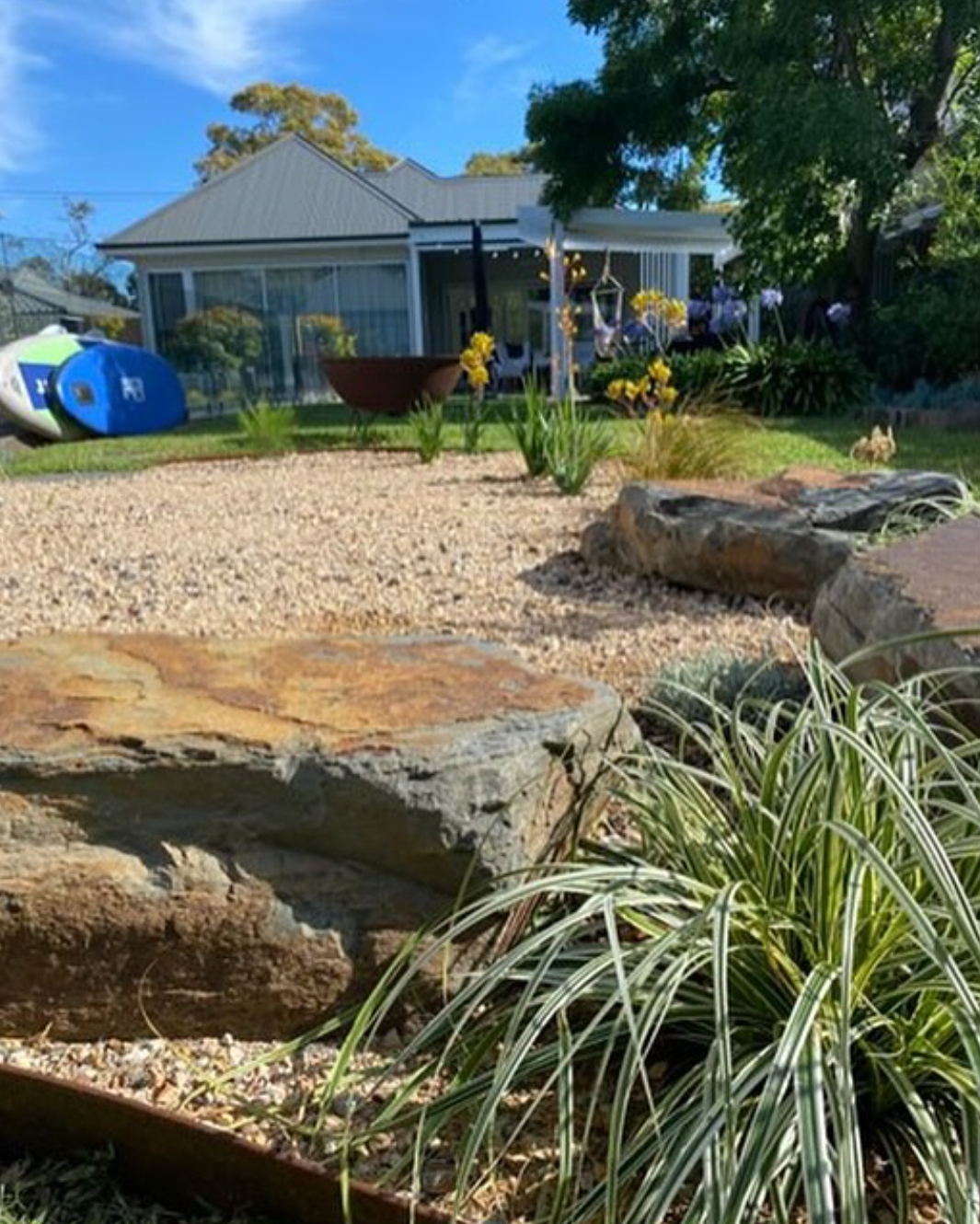 Albert Park garden with natural boulder feature, warm gravel surface and structured planted borders